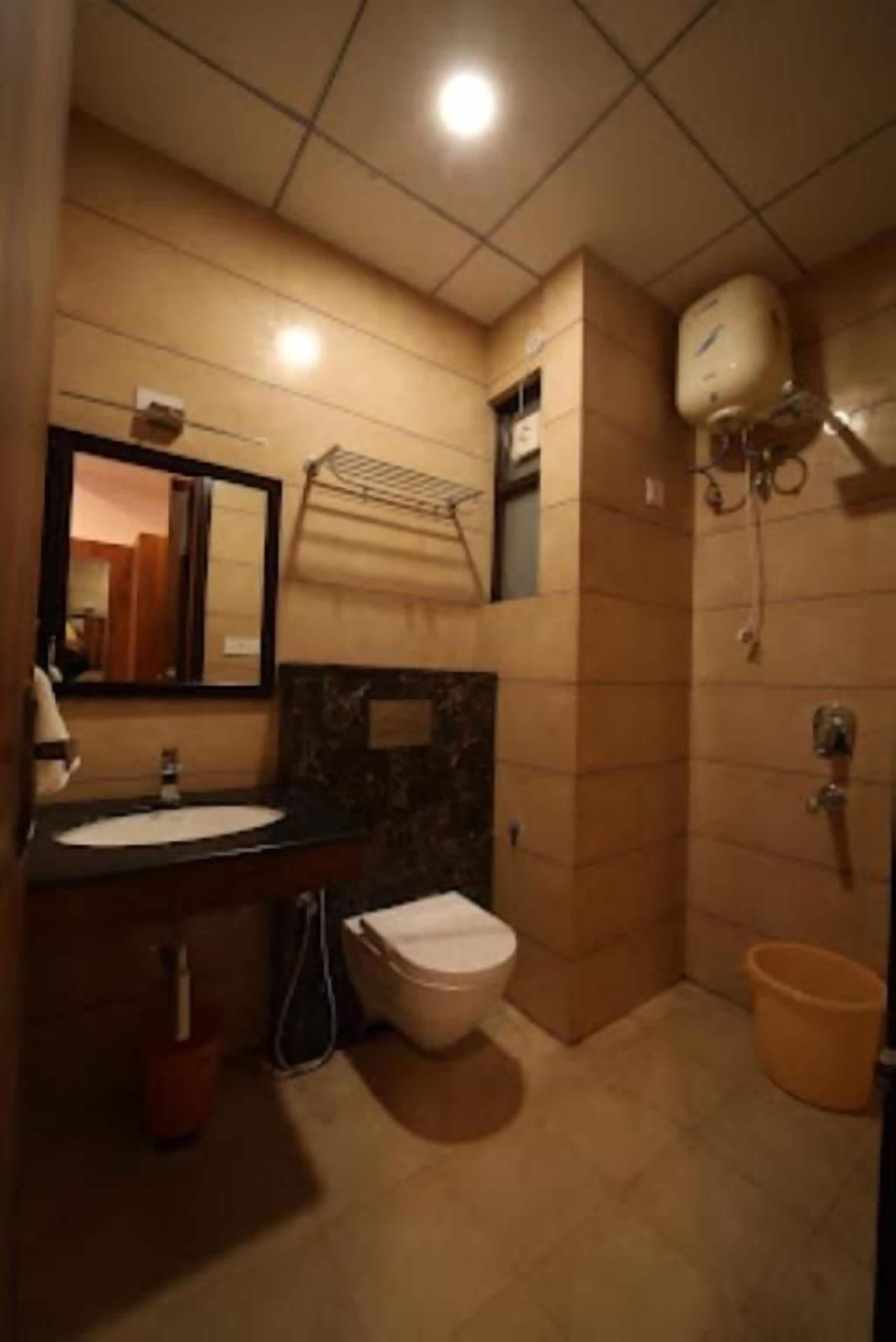 Casa de banho com lavatório, espelho, sanita e zona de duche.