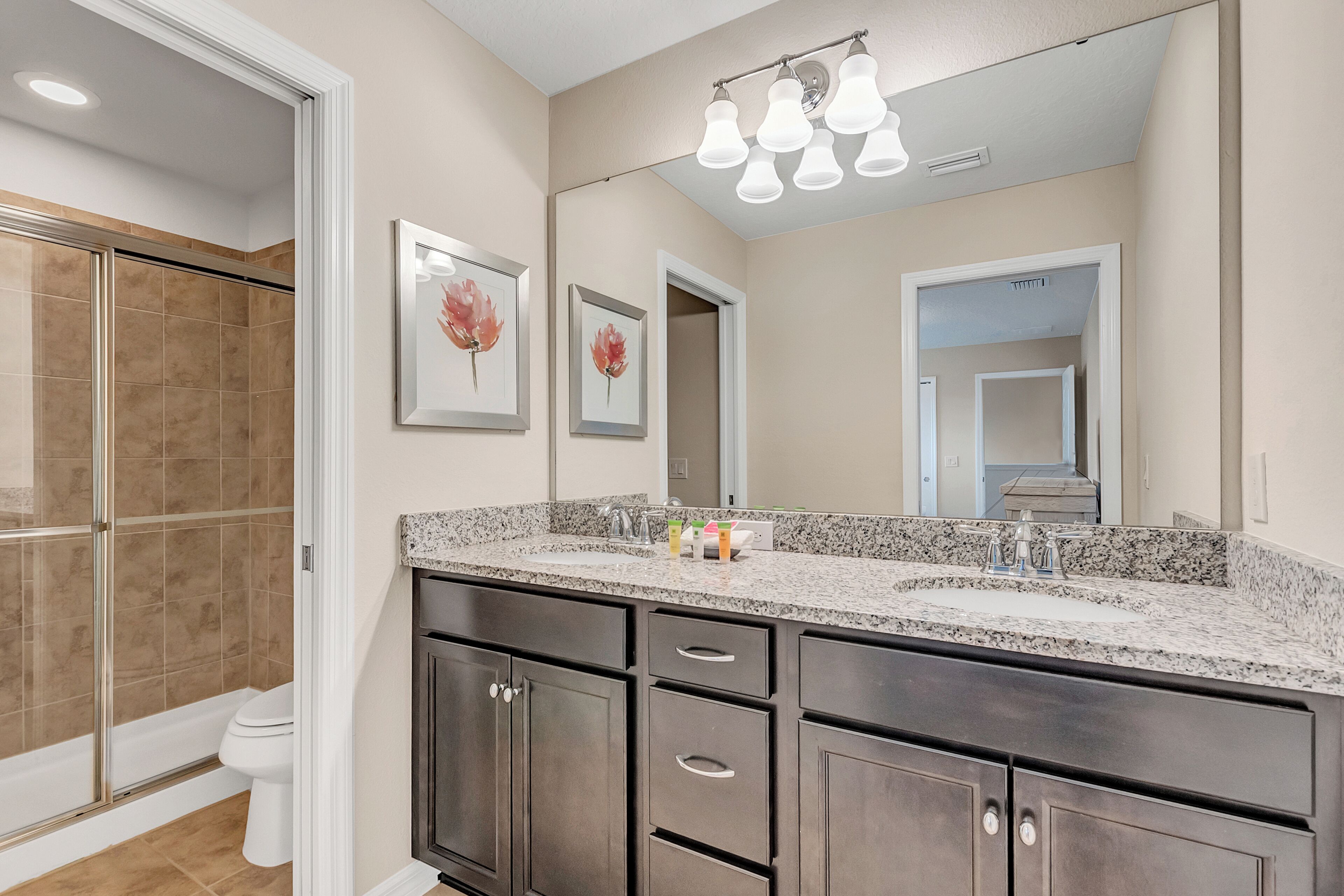 A bathroom with a large vanity, a shower, and a toilet.