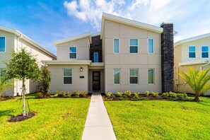 A modern two-story building with a flat roof, a central entrance, and a stone accent wall. - 4567 Narrative Lane (Kissimmee)