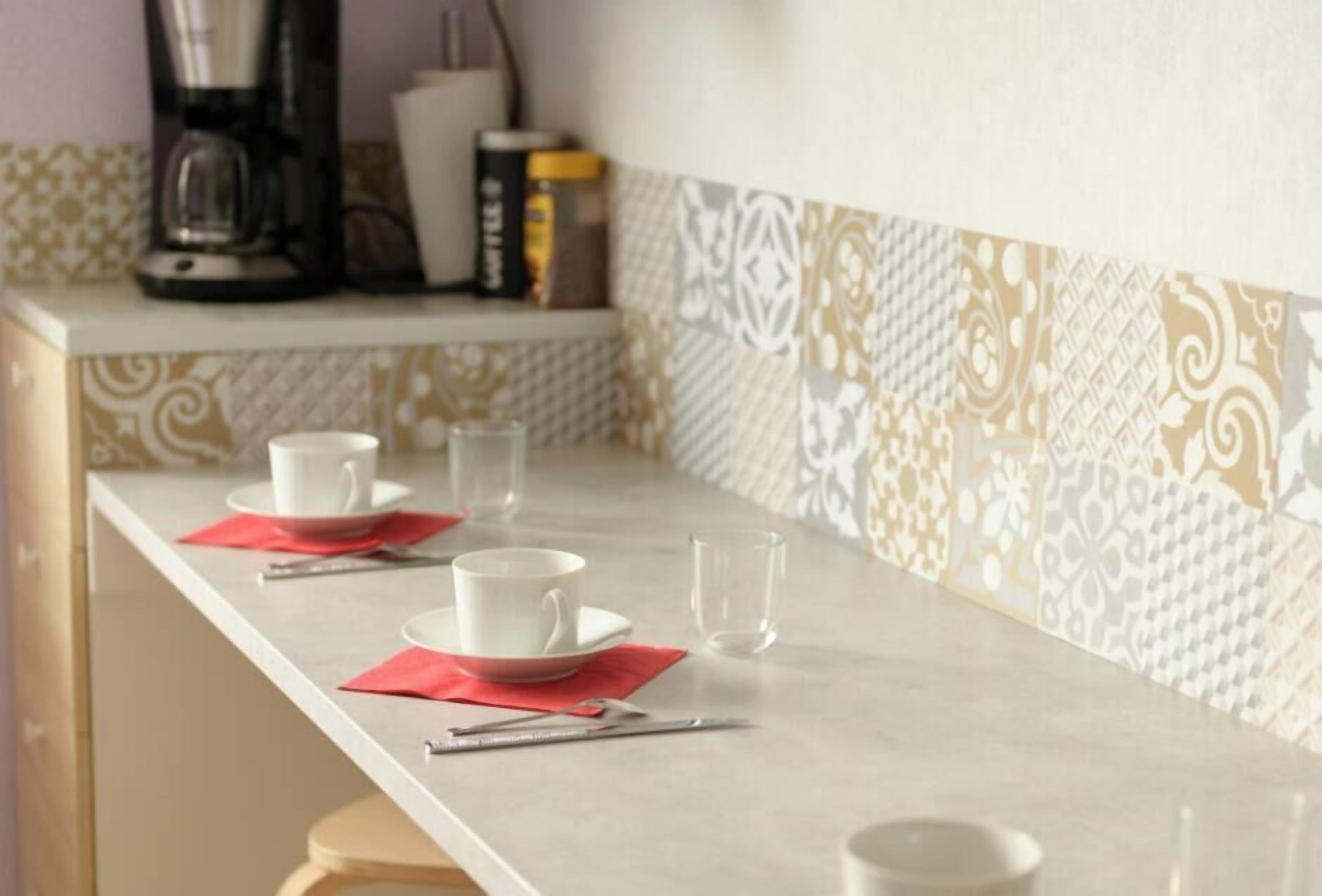 A kitchen counter with a coffee maker, a book, and a cup.