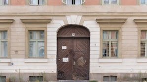 Ein großzügiger, reich verzierter Hauseingang mit einer markanten Bogenöffnung, der Hausnummer 8, und einem Schild, das eine Parkverbotszone kennzeichnet.