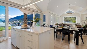 Een moderne keuken met een ruim kookeiland, een eethoek met uitzicht en een gezellige zithoek met uitzicht op de bergen.