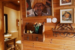 A wooden bathroom with a sink, toilet, and a decorative shelf with a vase. - Curry (Ramot)
