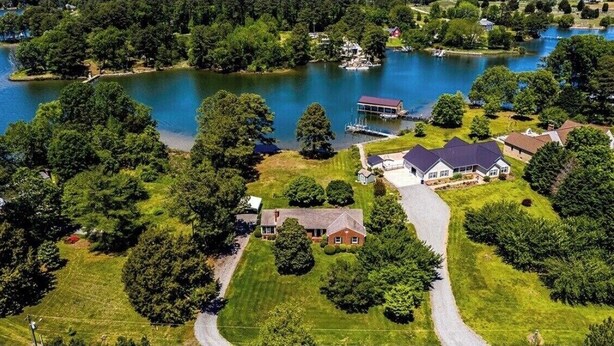 An aerial view of a residential area with houses, a lake, and a dock. - Secluded, Waterfront Retreat: Fire pit, Private Dock, Game Room, Kayaks! (Reedville)