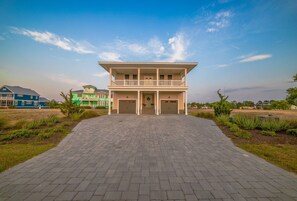 A two-story building with a front entrance, a covered porch, and a driveway leading to the entrance. - Beach Bums Home with Pool, Steps to the Beach (Cape Charles)