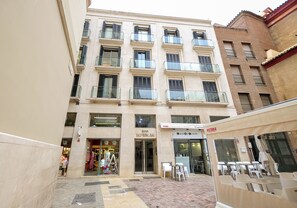 Ein mehrstöckiges Gebäude mit Café im Erdgeschoss, einem Boutique-Geschäft und einem Restaurant.