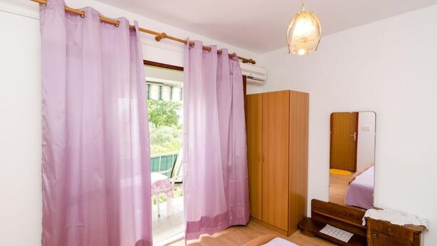 A bedroom with a bed, wooden wardrobe, and a mirror. - GH Kola (Dubrovacko Primorje)