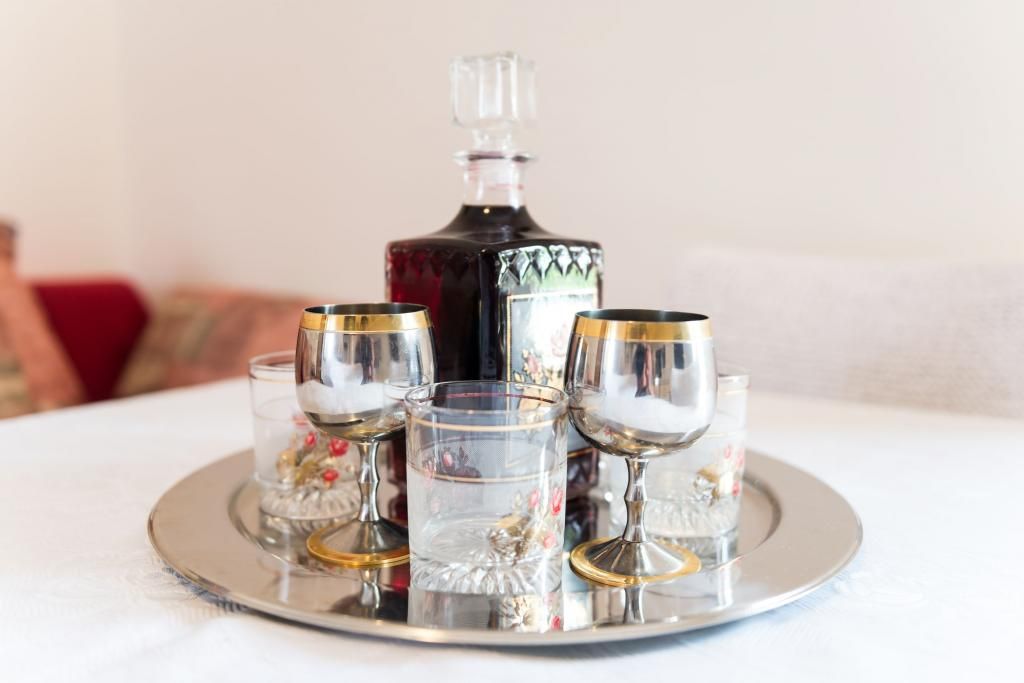 Un plateau avec une carafe et quatre verres, posé sur une table.