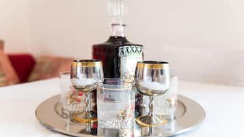 Un plateau avec une carafe et quatre verres, posé sur une table.