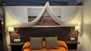 A hotel room with a bed, two nightstands, and a canopy over the bed. - House 1 suite Ragel coast (Palmar, El)