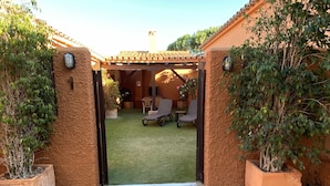 A courtyard with a pergola, two chairs, and a small table. - House 1 suite Ragel coast (Palmar, El)