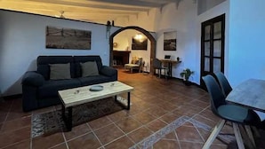 A living room with a sofa, a coffee table, and a dining area with a table and chairs. - House 1 suite Ragel coast (Palmar, El)