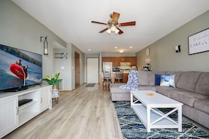 Relax in this stylish living room with a flat-screen TV, sofa, and coffee table.