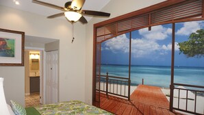 A bedroom with a large window offering a view of the ocean. - Riverside Island Bungalow (Daytona Beach)