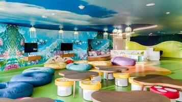 Explore an underwater world of play and imagination in this vibrant space, featuring colorful murals, cozy seating, and a flat-screen TV.