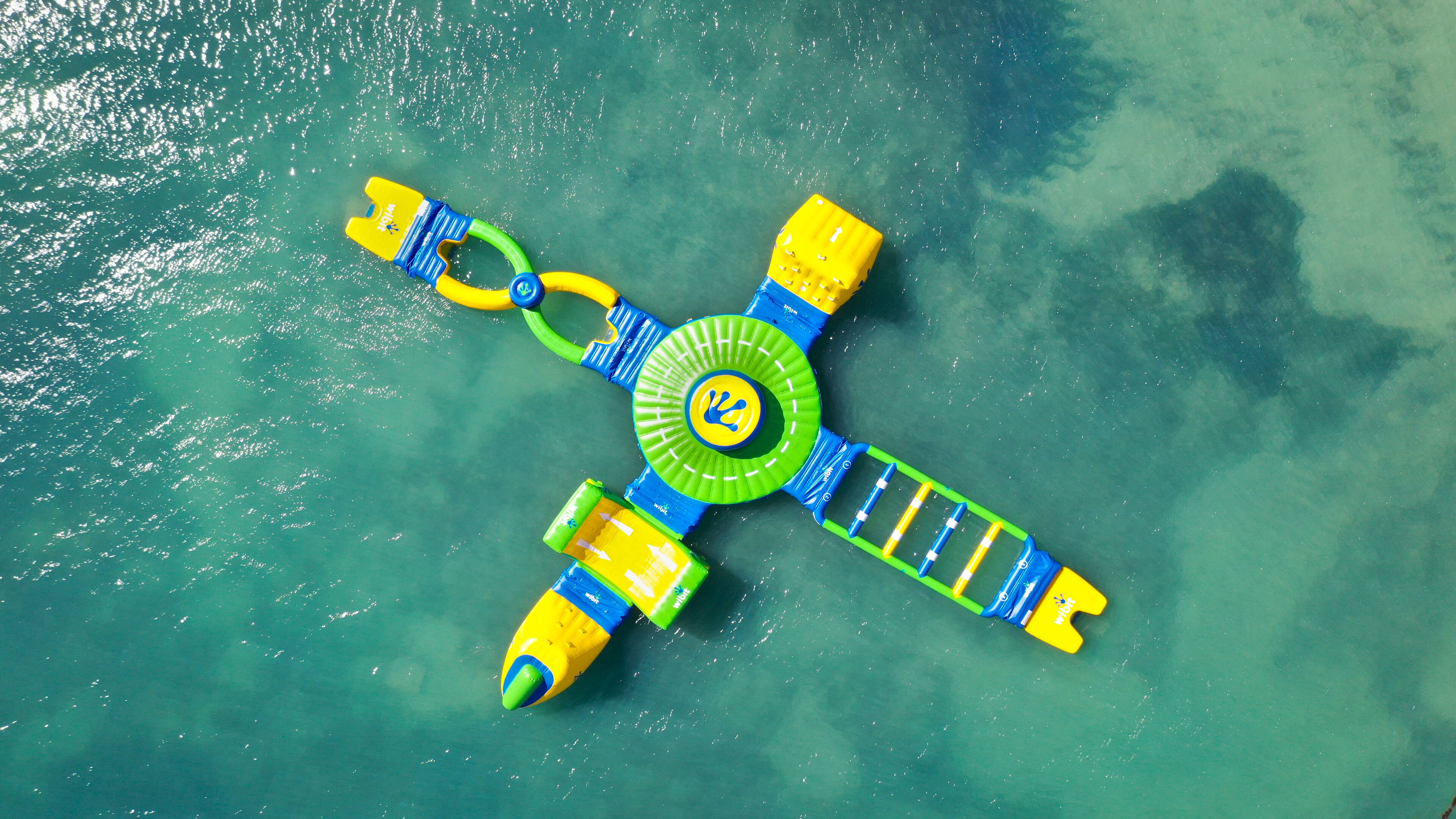 Un jouet flottant pour l’eau, composé d’une plateforme circulaire centrale et de quatre bras, et qui flotte sur une eau claire.