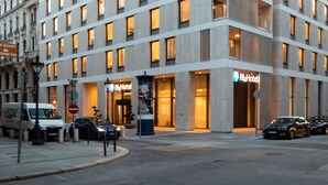 Een modern hotel met meerdere verdiepingen, grote ramen en een opvallend 'Hotel' bord.