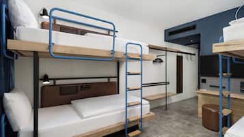A bunk bed room with a ladder, a desk, and a chair.