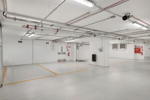 Un espacio interior limpio y bien iluminado con puertas numeradas, probablemente un garaje o instalación similar.