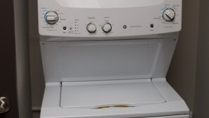 Eine weiße Waschmaschine und Trockner-Kombination mit sichtbaren Bedienelementen und Einstellungen.