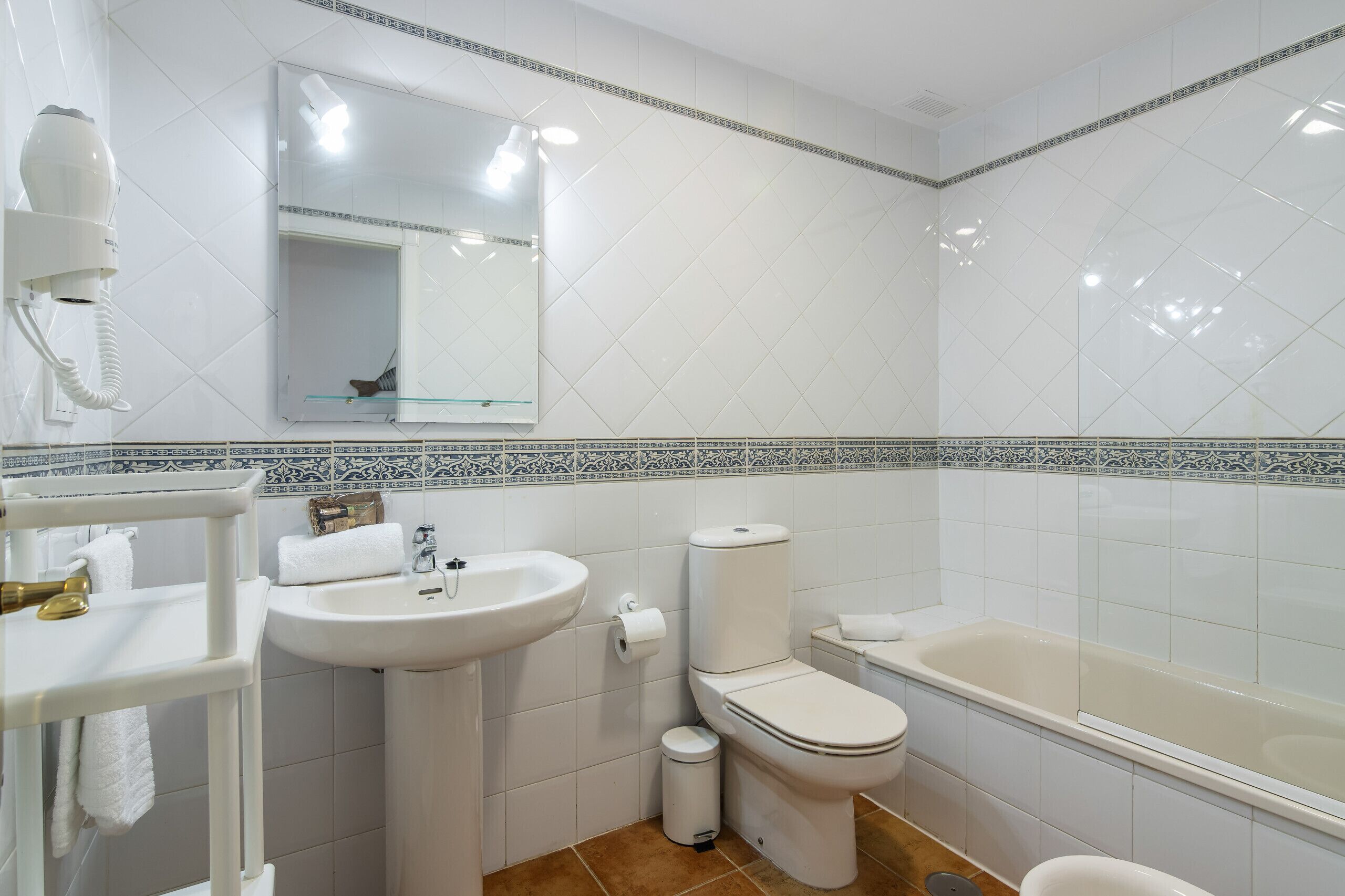 Une salle de bain avec un lavabo, des toilettes et une baignoire.