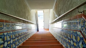 Eine Treppe mit aufwendig gefliesten Wänden und einem Metallgeländer.
