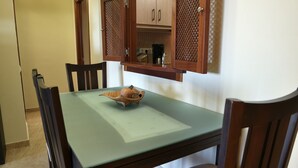 Een eettafel met een houten schaal en een glazen blad.