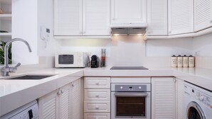 Eine moderne Küche mit Einbauofen, Mikrowelle und Kaffeemaschine.