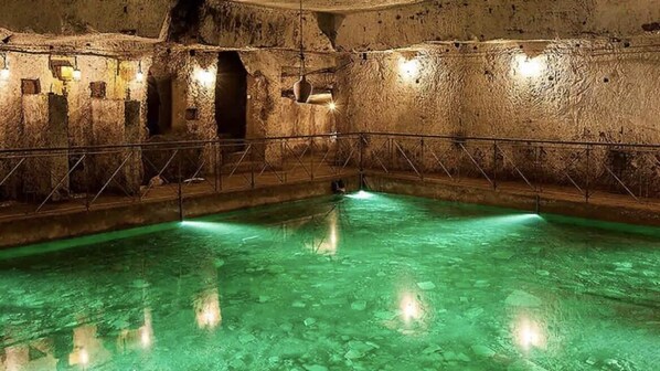 Relax by the serene pool surrounded by ancient stone walls.