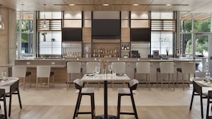 A modern restaurant with a bar area, large windows, and a clean, minimalist interior. - Hilton Garden Inn Austin North - Near the Domain (Austin)