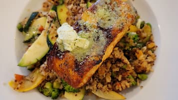 Un plato de comida con salmón, quinua y verduras.