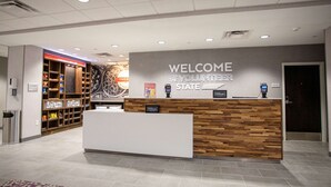 A reception area with a 'Welcome to the Volunteer State' sign, a wooden reception desk, a snack bar, and a 'Hilton Honors' sign.