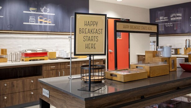 A modern kitchen area with a sign that reads "HAPPY BREAKFAST STARTS HERE" and another sign that says "HAPPY BREAKFAST STARTS HERE".
