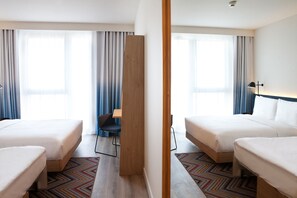 Une chambre d’hôtel avec deux lits, un bureau et une chaise.