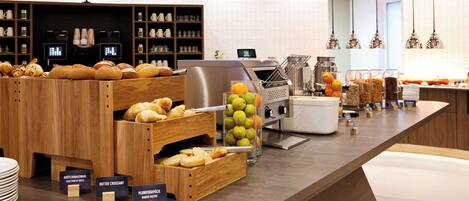 A bakery counter with various baked goods and a fruit display.