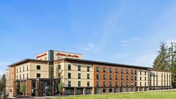 Hotel stands tall with a flat roof and symmetrical facade, featuring a grid of windows and a glass entrance.