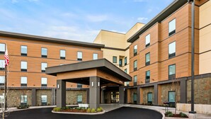 A modern hotel with a covered entrance, multiple floors, and a stone facade.