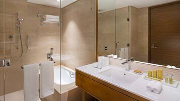 Une salle de bain moderne avec une douche à parois de verre, une baignoire et un meuble-lavabo doté d’un grand miroir.