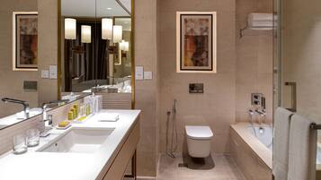 Une salle de bain moderne dotée d’un grand miroir, de deux vasques, de toilettes et d’un espace douche.