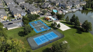 An aerial view of a residential area with a tennis court, a swimming pool, and a lake. - Hot tub!! Family Friendly - Loving Home (Kissimmee)