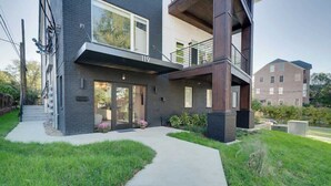 Un edificio moderno de dos pisos con techo plano, ventanas grandes y un balcón visible.
