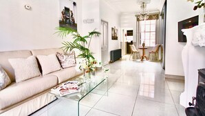 Ein modernes Wohnzimmer mit einer Couch, einem Glastisch und einer Deckenleuchte.