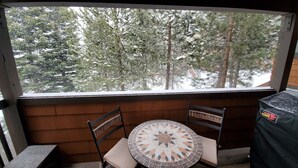 Ein überdachter Außenbereich mit Blick auf schneebedeckte Bäume.