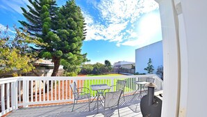 A deck with outdoor furniture, a barbecue grill, and a view of a backyard with a tree and a fence. - Family Retreat in The Village - Yard & Patio (Arroyo Grande)