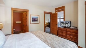 A bedroom with a bed, a dresser, a television, and a framed picture on the wall. - Spacious Corner VILLAGE Condo 2BD/2BA #2202 w/ Ski-back Trail close to GONDOLA (Mammoth Lakes)