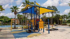 A playground with a climbing structure, swings, and a sandpit.
