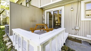 A white wooden deck with a picnic table and a small table, surrounded by a white fence. - Homey 3BR/2.5BA Townhouse, Walk to Big House! (Ann Arbor)