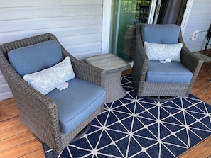 Two wicker chairs with blue cushions and patterned pillows, a small round table, and a geometric-patterned rug on a wooden deck. - Quiet Townhouse - Cozy Gas Fireplace - Near Lake Chatuge (Hayesville)