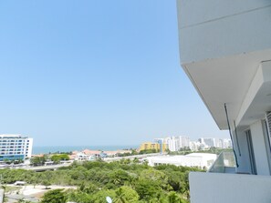 A balcony with a view of a cityscape, including buildings and a clear sky.