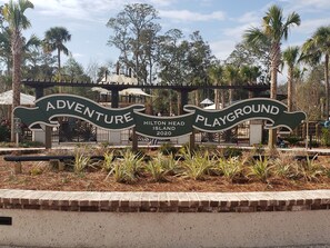 A sign for Hilton Head Island's Adventure Playground with a brick border and tropical plants. - Awesome Ocean View! Coligny Area! Updated and CLEAN 1 Bedroom! #380 (Hilton Head Island)